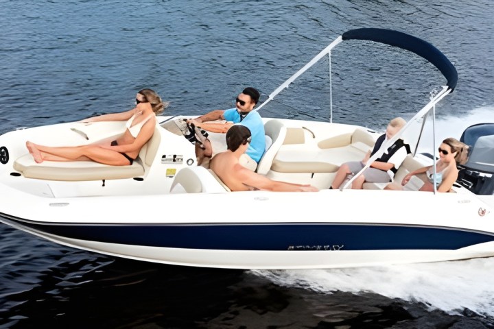 Family enjoying a ride on a small motorboat with a canopy on a sunny day.