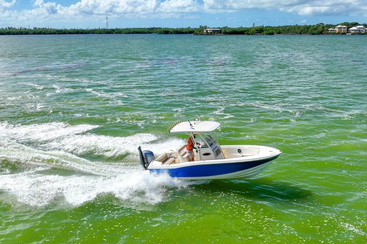 a man riding on the back of a boat in the water