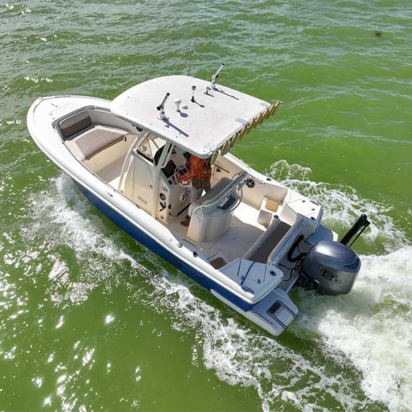 Aerial view of a small motorboat with a canopy cruising on green water.