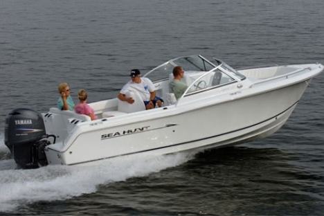 Family enjoying a ride on a white Sea Hunt motorboat on open water.
